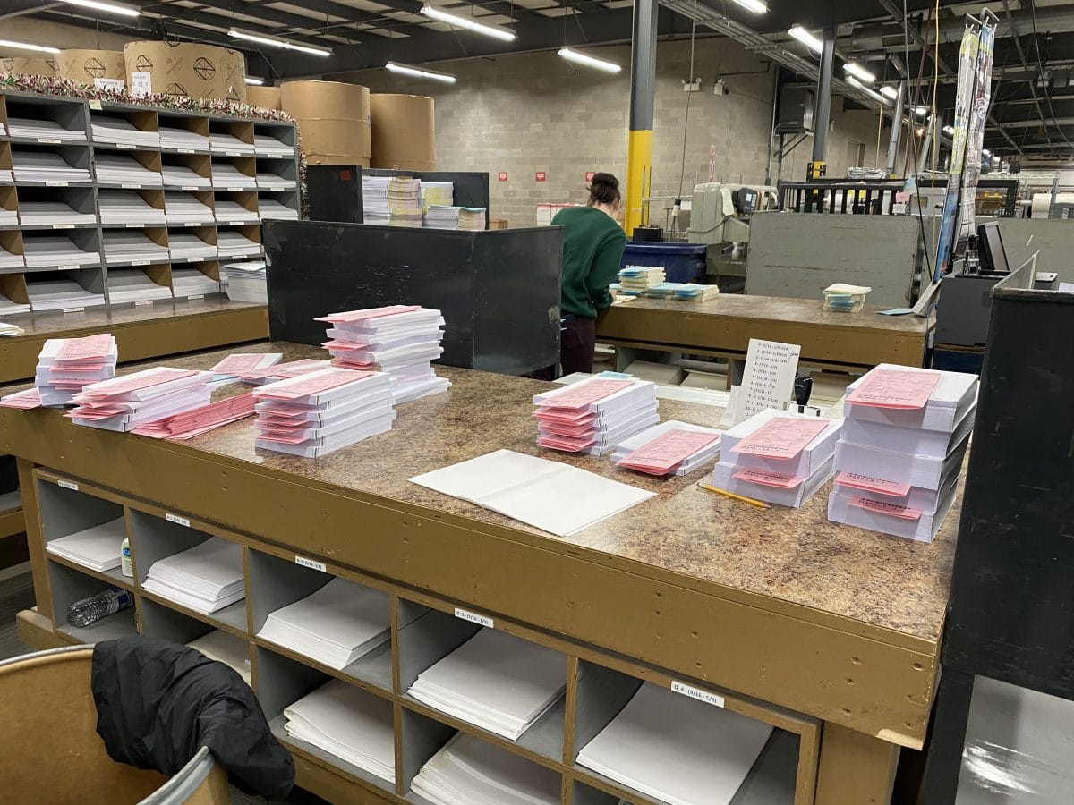 Here you can see freshly cut stacks of pages, grouped together as the complete interior of a book. The pink slips of paper include all the relevant data about the book, including trim size, binding details, and where it’s eventually going!