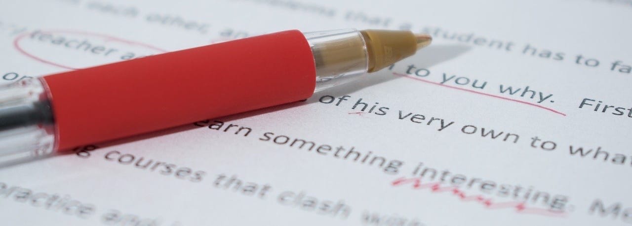 A red ballpoint pen, commonly used for editing